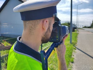 umundurowany policjant dokonuje pomiaru prędkości