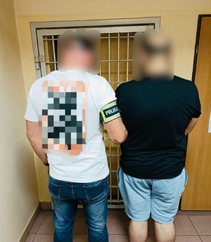 policjant z zatrzymanym mężczyzną