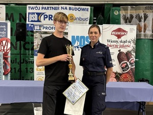 umundurowana policjantka stoi przy autorze najlepszego modelu kartonowego pojazdu cywilnego, który otrzymał puchar Komendanta Policji w Pabianicach