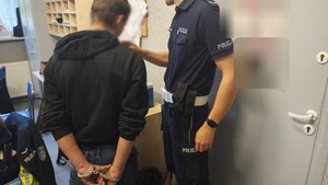 umundurowany policjant bada zatrzymanego na zawartość alkoholu w pomieszczeniu Komendy Powiatowej Policji w Pabianicach