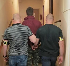 policjanci podczas doprowadzenia podejrzanego