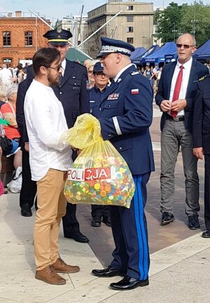 Komendant Wojewódzki Policji w Łodzi nadinsp. Andrzej Łapiński przekazuje symboliczny worek z nakrętkami wiceprezesowi stowarzyszenia